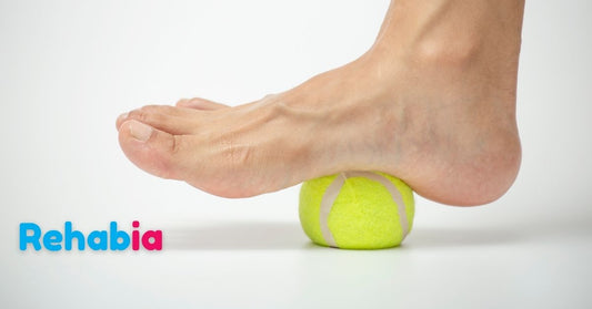 Fot som rullar över en boll för att minska smärta vid hälsporre och plantar fasciit